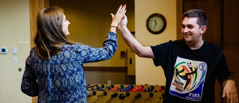 Women and young man giving each other a high-five.