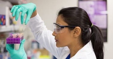 Female lab technician holding test tubes.