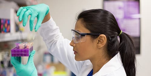 Female lab technician holding test tubes.