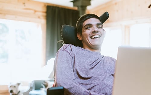 Adult smiling while working on his computer.