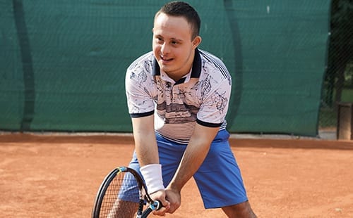 Adult male playing tennis.