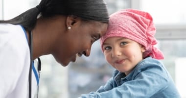 Nurse with little girl smiling.