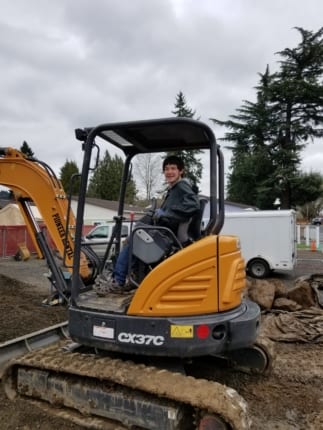 Male adult driving a forklift.