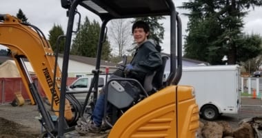 Male adult driving a forklift.