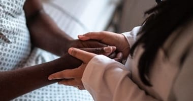 A doctor holding their patient's hands