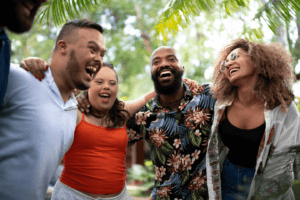 A group of four people smiling and standing with their arms wrapped around each other