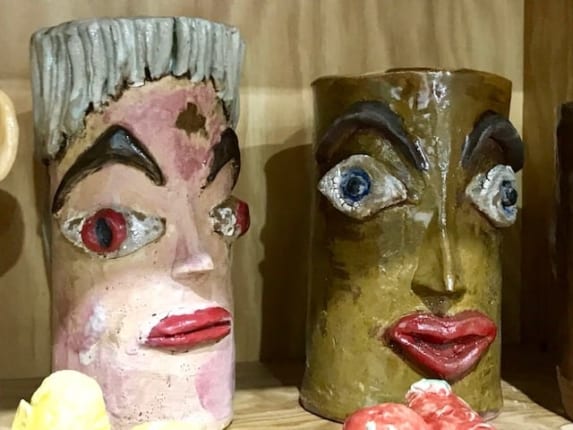 Ceramic faces on display for art show.