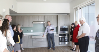 Visitors to Wynne Watts Commons get a demonstration of the accessible features of an apartment's kitchen.