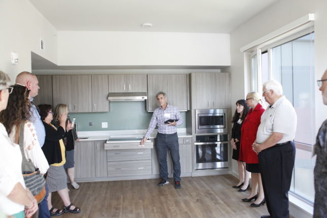 Visitors to Wynne Watts Commons get a demonstration of the accessible features of an apartment's kitchen.