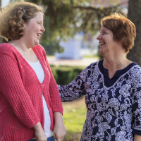 Mother and daughter smiling outside.