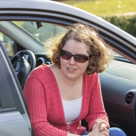 Young woman with sitting in her car.