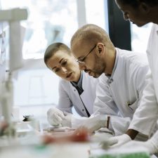 A group of medical doctors sitting at a table reviewing paperwork.